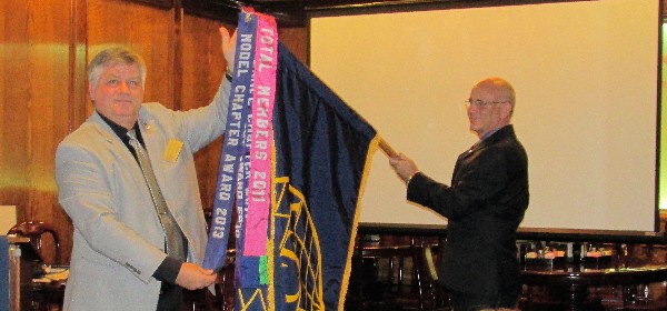 Col. Kelly Crooks, USAF (Ret.) (l), regional vice president for Texas, presents the chapter’s Model Chapter of the Year Award streamer to Lt. Col. Chris Van Dyke, USA (Ret.), chapter president, during the October general membership meeting.